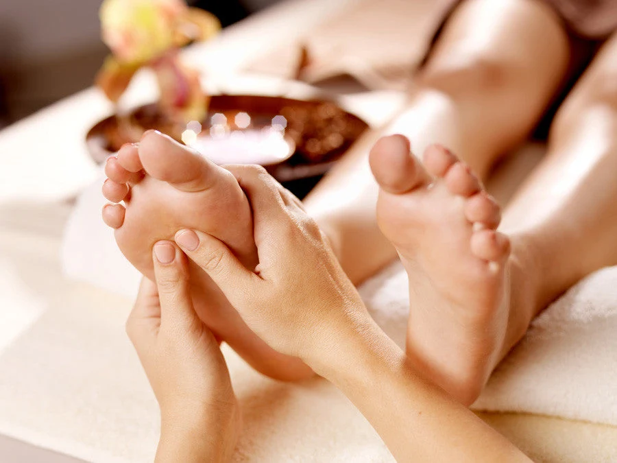 Foot massage with lotus flowers alongside